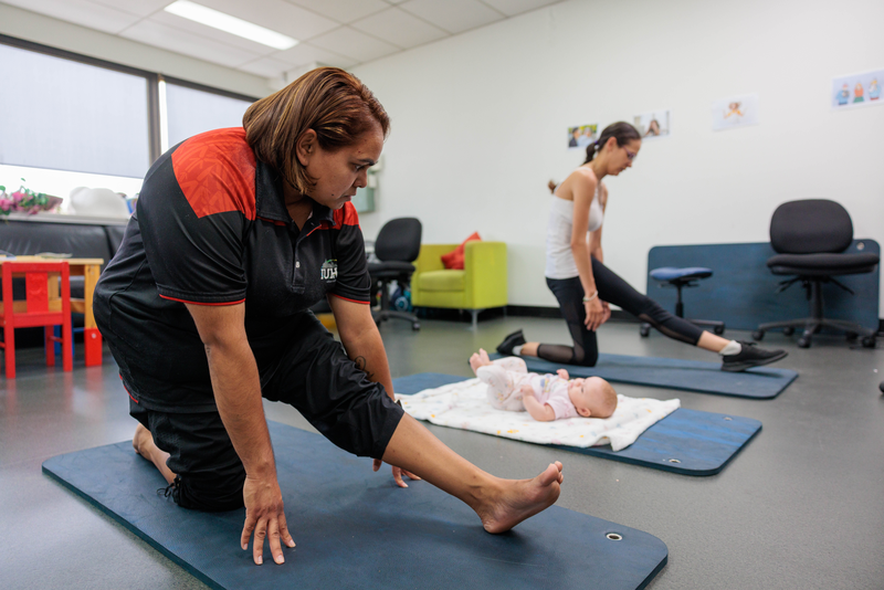 Mum, baby and staff member performing exercises