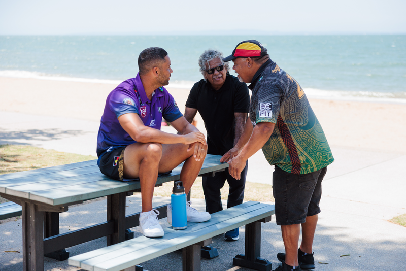 3 Deadly Moreton ATSICHS staff members having a yarn near the ocean.