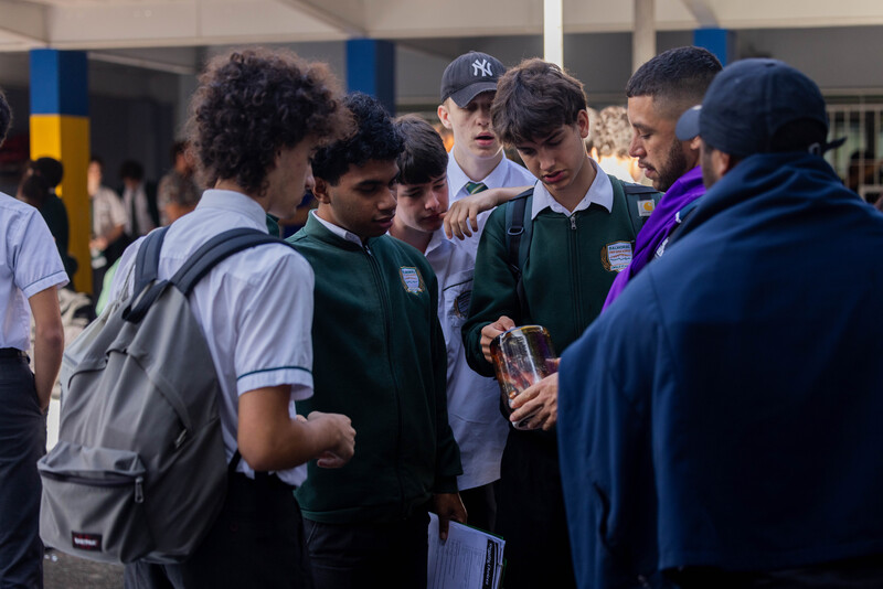 Deadly Choices Education Program officer in a yard with a small group of high school students.