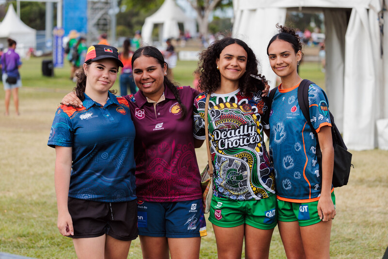 A group of four young deadly girls, wearing Aboriginal jerseys.