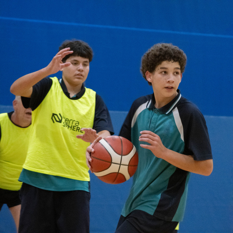 Two students playing basketball at Basketball Hoops Dreaming event